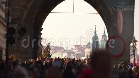 很多人走在老城塔楼的背景上。视频