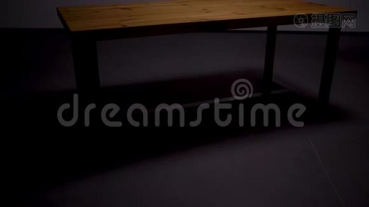 空房间里的时尚木桌。 库存录像。 美丽的木制桌子，铁腿矗立在空灰色的中间视频