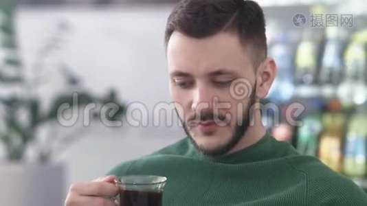 穿着绿色毛衣和咖啡的帅哥视频