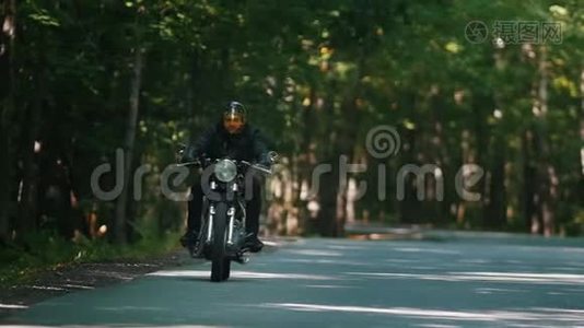 一个戴着头盔骑着摩托车的野蛮人骑着摩托车在森林里视频