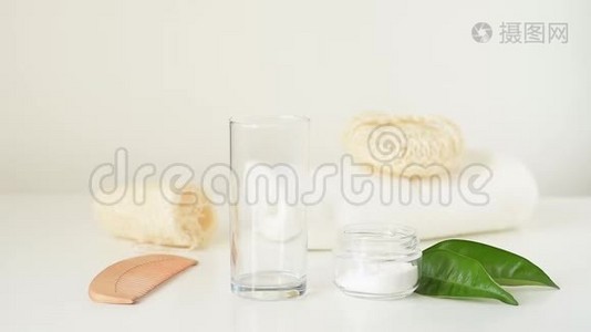 木制竹制牙刷在白色背景上落入玻璃和浴室零废品中视频