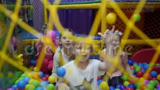 孩子们`游戏室。 幼儿在装满塑料彩球的干盆里玩..视频