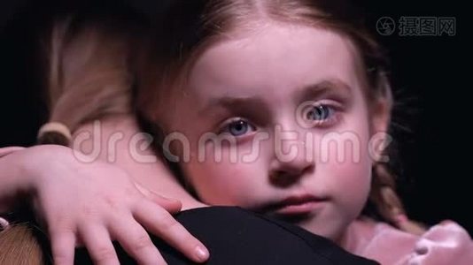 一个满脸泪水的小女孩拥抱着养母，一个需要家人陪伴的孤儿视频