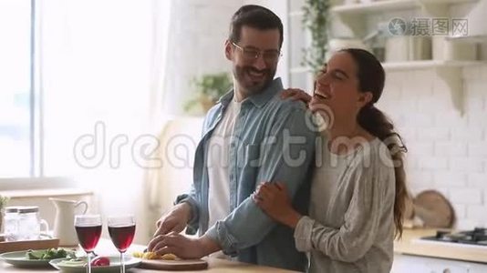 快乐的年轻夫妇一起做饭，一起准备厨房里健康的饭菜视频