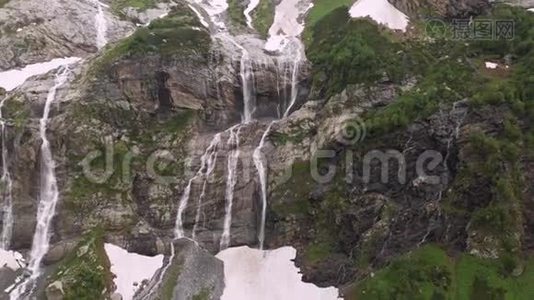 空中观景无人机拍摄到几条瀑布从陡峭的大山岩上流下来，这些岩石被郁郁葱葱地包围着视频