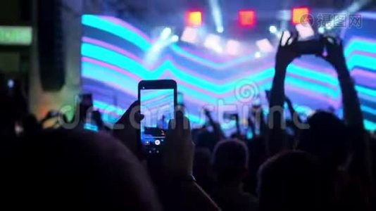 人们正在用智能手机拍摄歌手音乐会视频