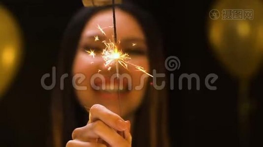 微笑的亚洲女人向镜头展示孟加拉灯，新年公司聚会视频