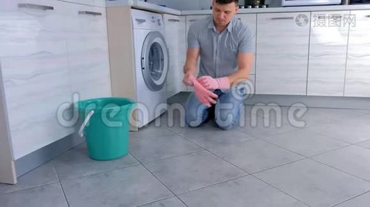 快乐男人戴上橡胶手套清洁厨房。视频