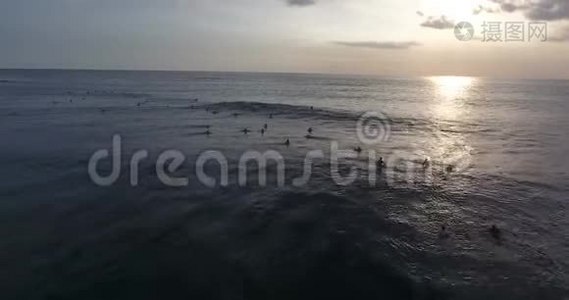 美丽的波浪海洋，五彩缤纷的日落，人们游泳冲浪，空中射击视频