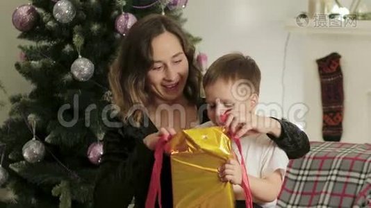 可爱，快乐，兴奋的妈妈和儿子在一个漂亮的房间里打开了一个圣诞礼盒。视频