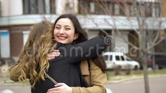 女孩的友谊。 两个女朋友在街上相遇。 他们拥抱。 女孩们很高兴见面。 他们很快乐视频