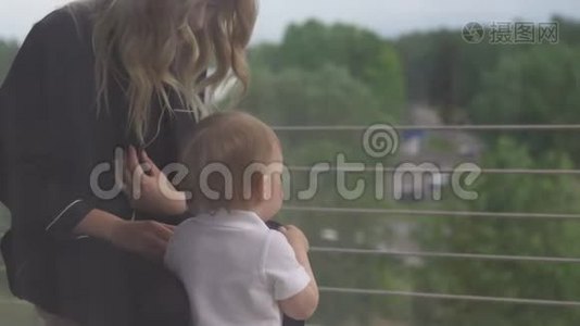 年轻的金发母亲带着悲伤的男婴透过窗户，思考着生活的目的-穿着黑色的胸衣视频