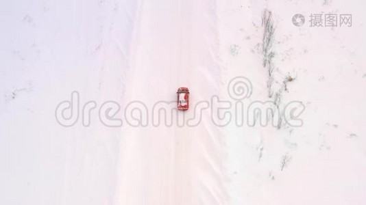 一辆车正沿着一条冬天下雪的乡村道路行驶。 从无人驾驶飞机上俯瞰。视频