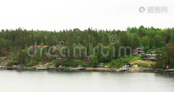 夏季多云天气，岛上海岸的许多红色瑞典木制桑拿木屋视频