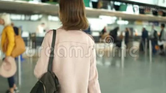 棕色头发的女人在机场的登记台排队。 旅行概念视频