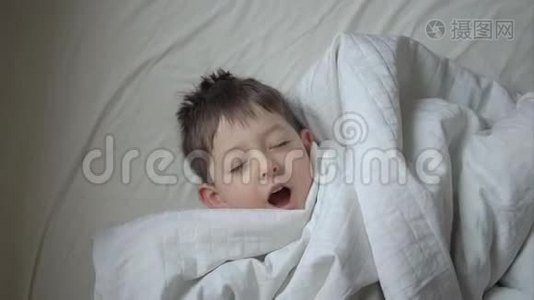家中躺在床上的可爱小男孩的俯视图视频