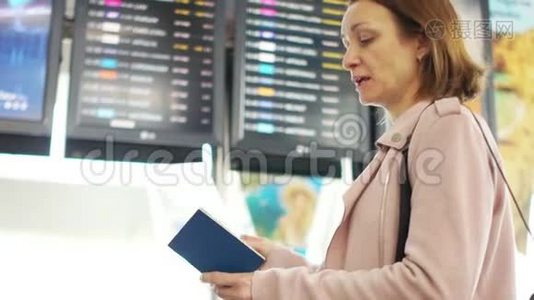 成熟的女人独自站在机场航班时刻表附近。 查看离境信息委员会，视频