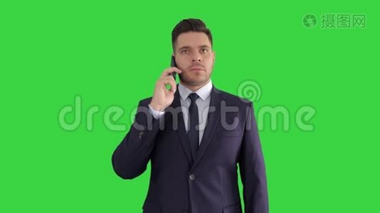 商人在绿色的屏幕上仔细地听电话，色度键。视频