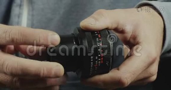 男性手的特写镜头指向镜头的宏环。 摄影师将宏环安装到手动镜头。 电影4K录像视频