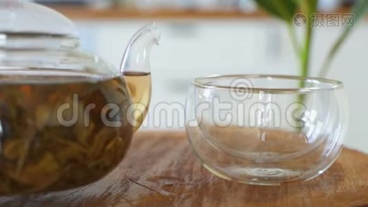 喝茶。 茶被倒入玻璃透明茶杯中。 喝茶的时候。 透明玻璃茶壶和茶杯。视频