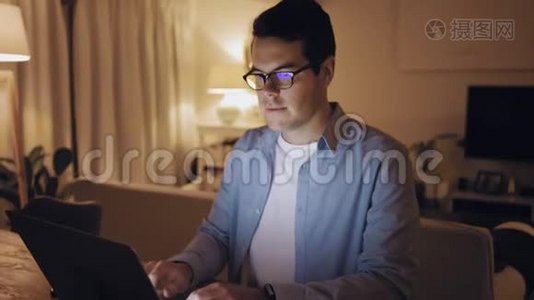 中年男子在客厅里用笔记本电脑工作到很晚视频