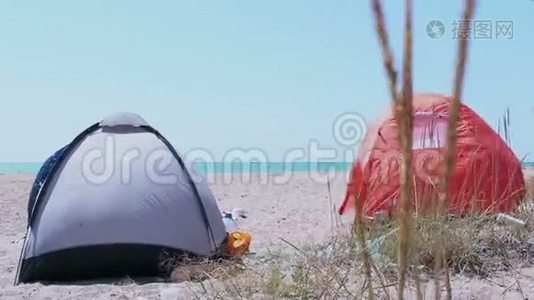 旅游帐篷矗立在沙滩上。 站在荒无人烟的沙滩上的旅游帐篷。视频
