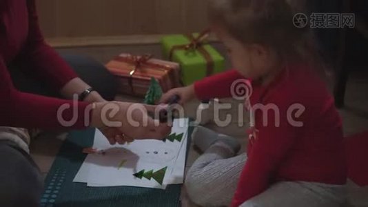 一个普通的计划，妈妈和小女儿用纸贴花堆雪人。视频