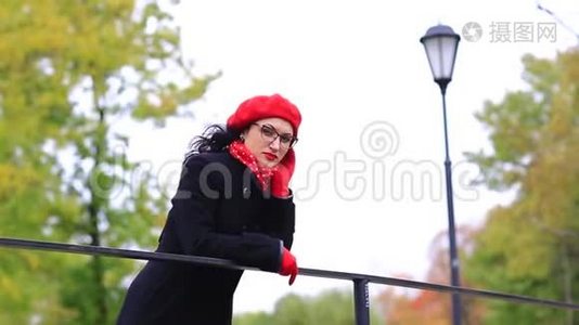 一个戴着红色贝雷帽和眼镜的女人站在桥上视频