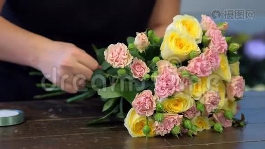 花匠制作花束，玫瑰花茎与丝带，手特写。视频