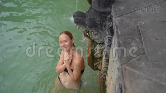 年轻女性游客参观巴厘岛著名的班贾尔温泉。 巴厘旅行构想。 慢镜头视频