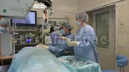 手术室的一组外科医生用外科显微镜对耳鼻喉科器官进行显微手术视频