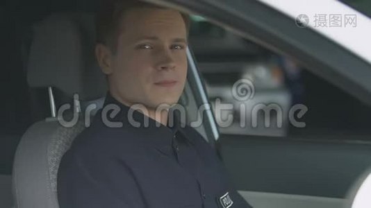 友好的警察微笑着坐在巡逻车的驾驶座上视频