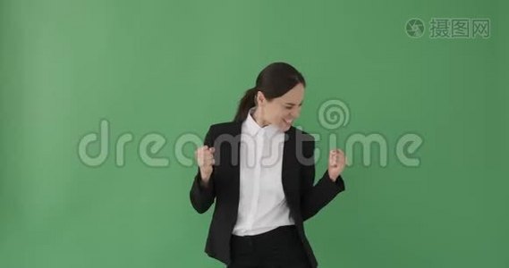 兴奋的女商人在绿色背景下跳舞视频