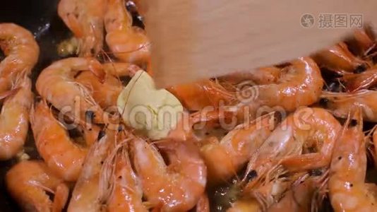虾仁放入黄油，放入锅中煎，用木抹子搅拌..视频