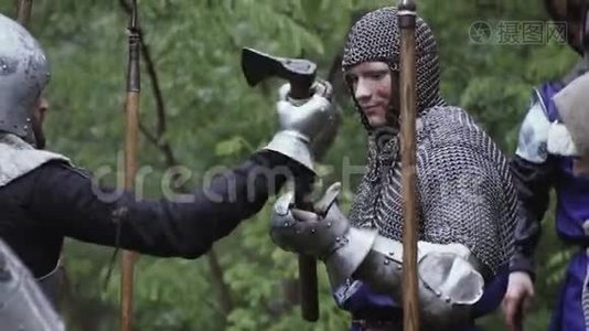 穿链甲的战士拿着斧头，森林里的军队，中世纪的战斗视频
