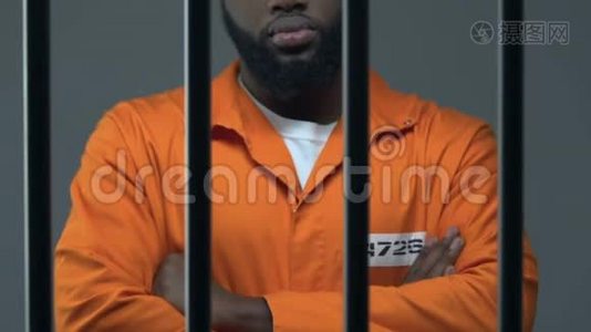 双手交叉的黑人罪犯站在监狱里等待判决视频