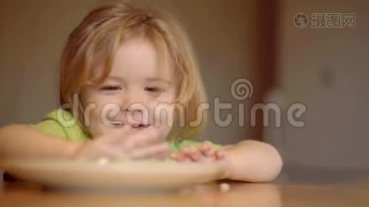 快乐的小男孩勺子吃自己。 宝宝吃。 快乐的小男孩勺子吃自己。 儿童保育。 快乐的孩子吃早餐视频