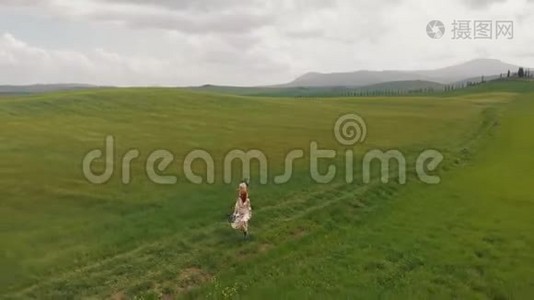 两个年轻迷人的女人正沿着绿色的草地散步。 无人机离开他们。 意大利，托斯卡纳。视频
