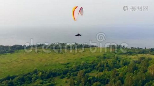 一个运动员用滑翔伞在空中飞行。 空中滑翔伞。视频