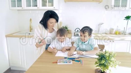 妈妈帮助两个儿子在相册里画记号。 学前教育视频