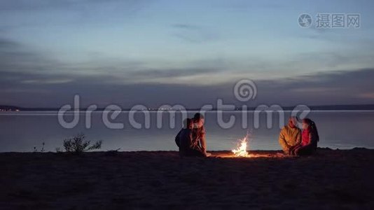 一家带孩子的旅行者在海边的篝火旁休息视频
