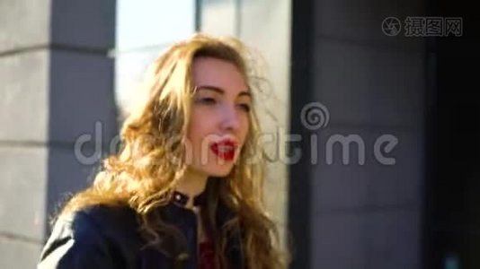 美丽的金发女人的肖像，红唇在阳光下漫步在街上视频