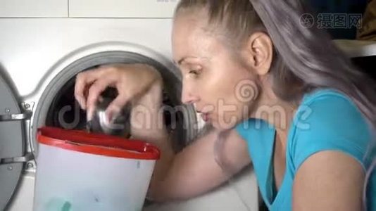 年轻女子准备在洗衣机里洗衣服，拿出并打开装有洗衣粉的盒子视频