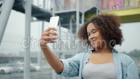 漂亮的非裔美国女人在户外用智能手机自拍的慢动作视频