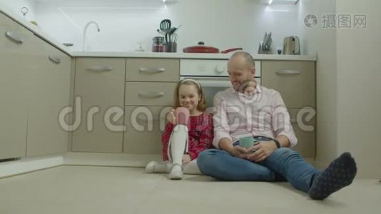 父亲和女儿在厨房的地板上放松视频