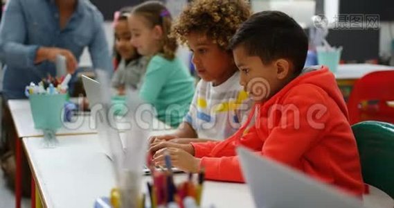 4k教室里在笔记本电脑上学习的混血学童的侧视图视频
