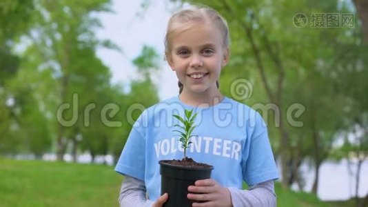 开朗的女孩子手持植物微笑相机，保护自然资源视频