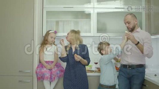 快乐的父母和兄弟姐妹在厨房分享水果视频