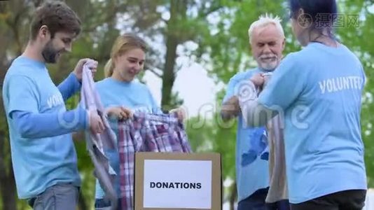 快乐的积极分子把捐赠的衣物放在盒子里，给高五，做志愿者视频