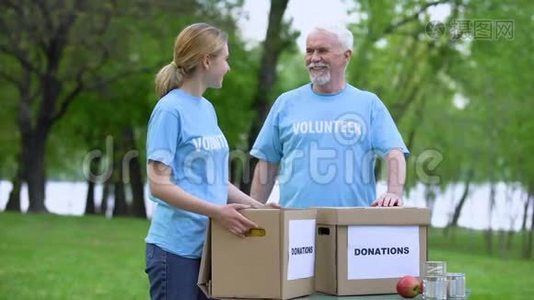 志趣相投的志愿者们手捧着捐款箱，在公园里微笑，无私奉献视频